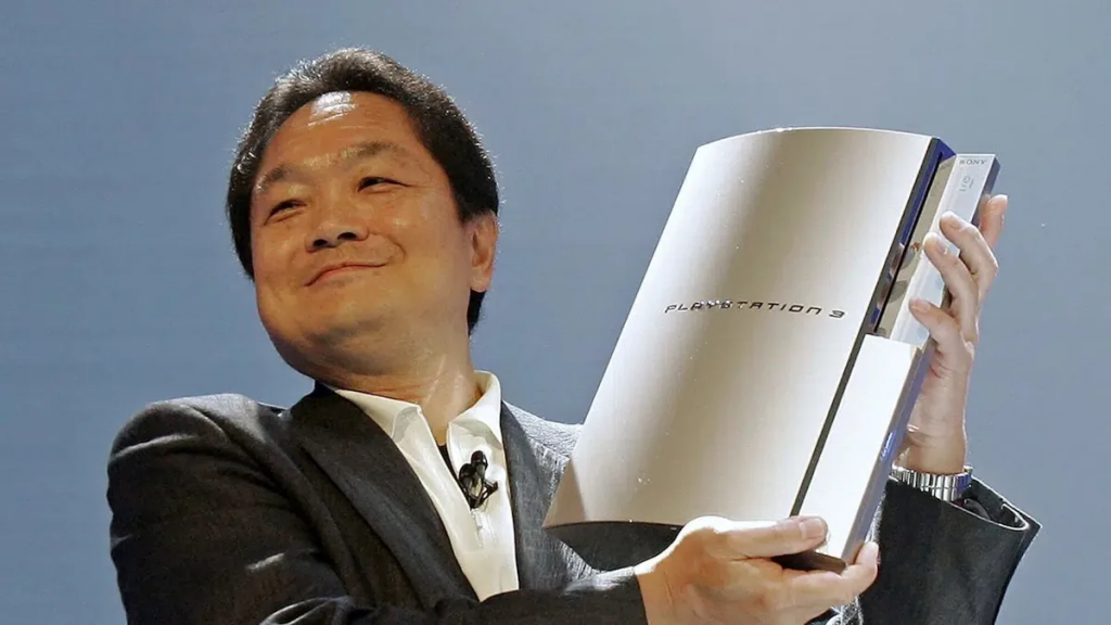 Ken Kutaragi, criador do PlayStation segurando a versão o console nos braços.